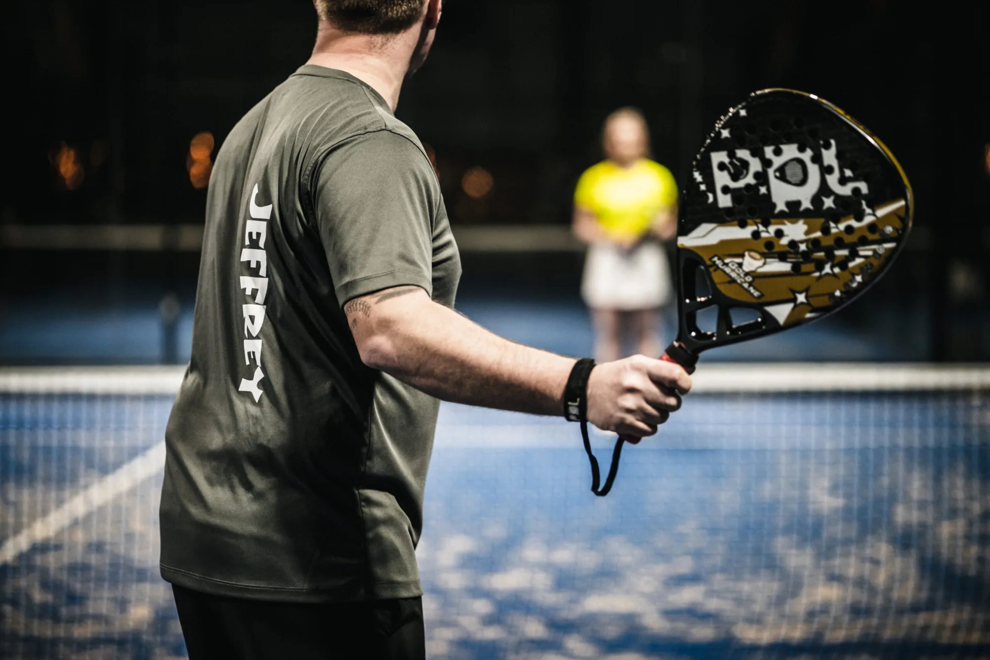 Padelspeler in een Padel Sportswear-shirt tijdens een training op de baan