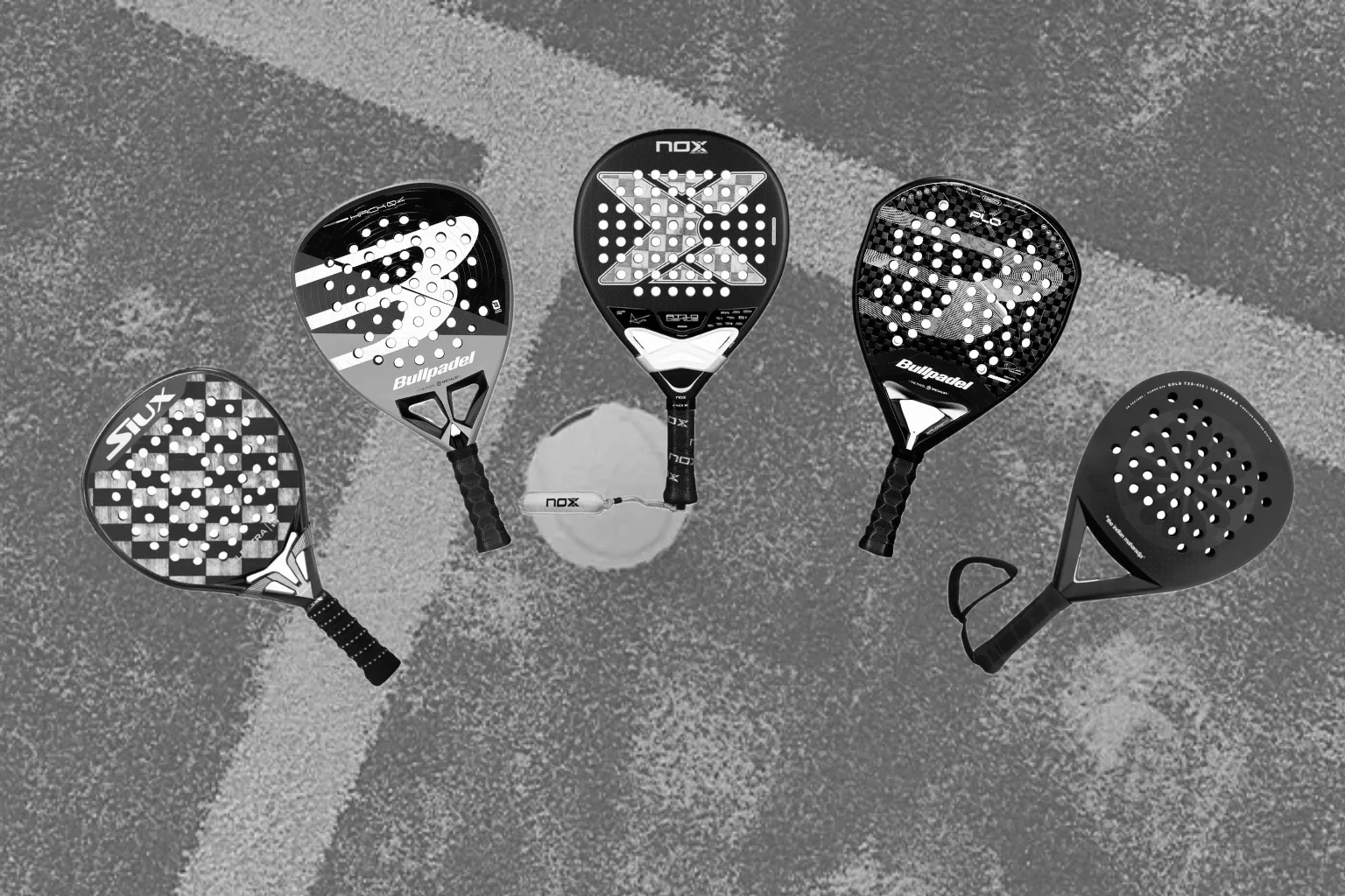 Padelrackets naast elkaar op de padelbaan